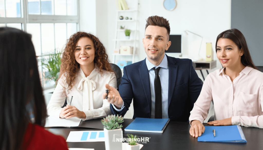 two women and a man in a business office participating in an interview or new hire onboarding session.
